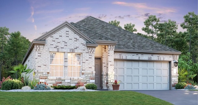 view of front of home featuring a garage and a yard