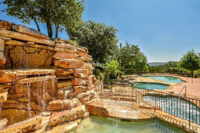 view of pool with a hot tub and a patio area