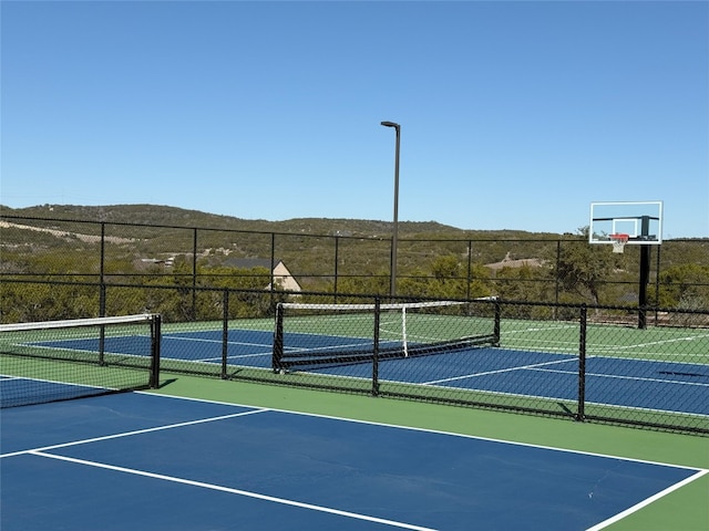 view of tennis court featuring a mountain view