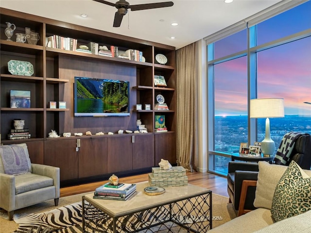 living room featuring expansive windows, ceiling fan, and light hardwood / wood-style floors