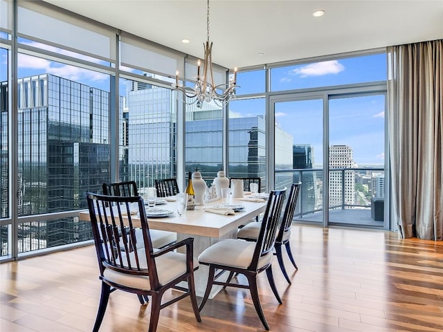 dining space with a notable chandelier, light hardwood / wood-style flooring, and floor to ceiling windows