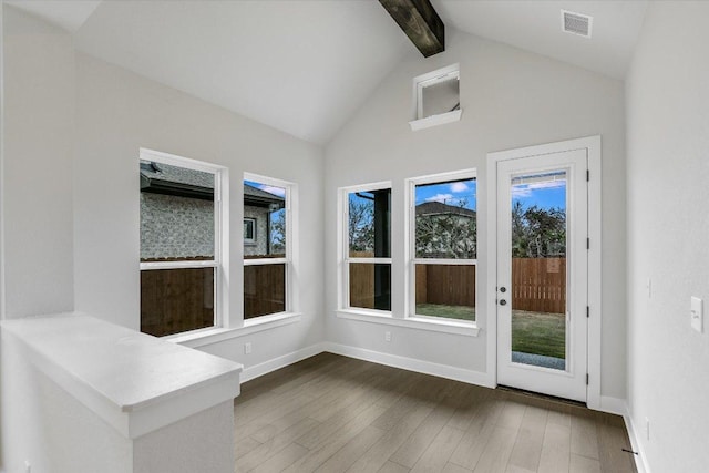 unfurnished sunroom with visible vents and lofted ceiling with beams