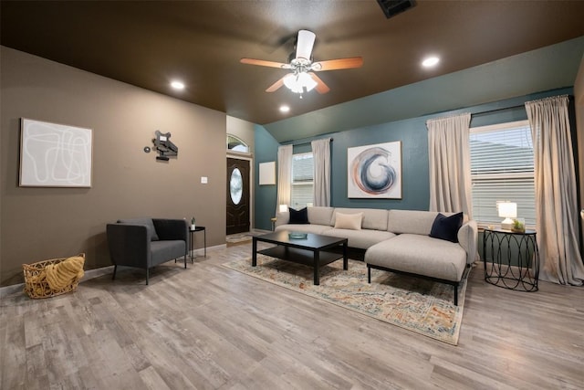 living room with ceiling fan, lofted ceiling, and light hardwood / wood-style flooring