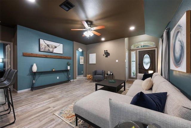 living room with ceiling fan, lofted ceiling, and light wood-type flooring