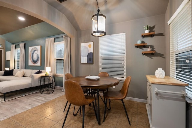 dining room featuring lofted ceiling and light tile patterned floors