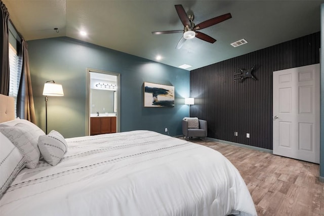 bedroom featuring lofted ceiling, hardwood / wood-style floors, ceiling fan, and ensuite bathroom