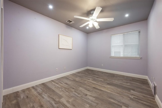 spare room featuring dark hardwood / wood-style floors and ceiling fan