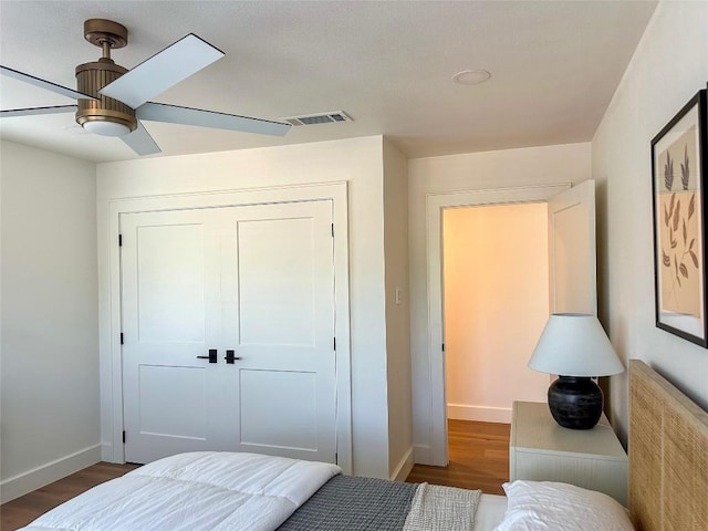 bedroom featuring dark hardwood / wood-style floors, ceiling fan, and a closet