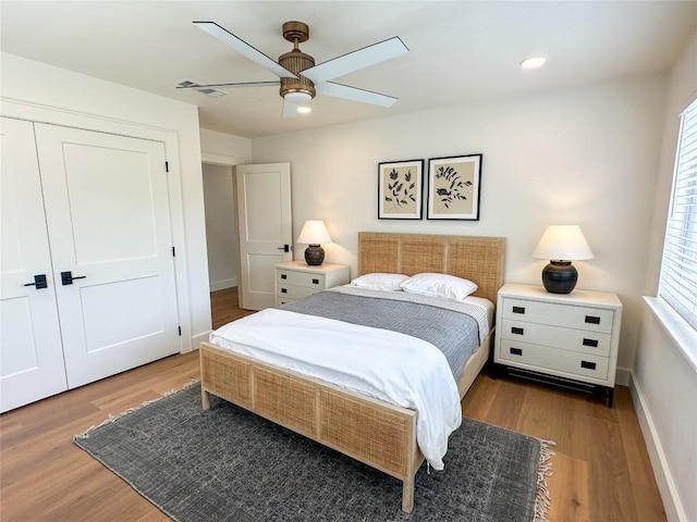 bedroom with hardwood / wood-style flooring, a closet, and ceiling fan