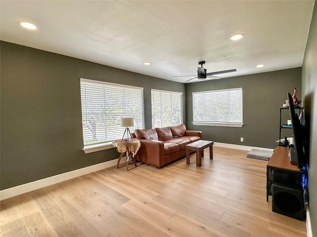 living room with light hardwood / wood-style flooring and ceiling fan