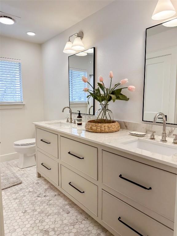 bathroom featuring vanity, toilet, and a healthy amount of sunlight