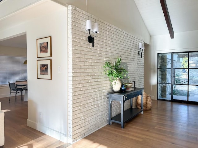 hall with beam ceiling, hardwood / wood-style flooring, high vaulted ceiling, and brick wall