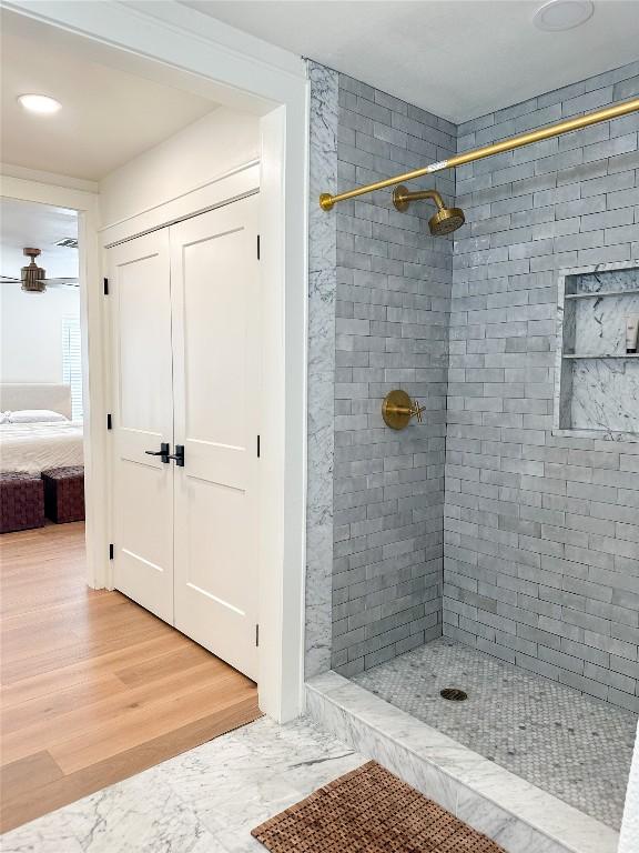 bathroom featuring hardwood / wood-style floors and a tile shower