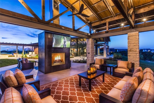 patio terrace at dusk featuring an outdoor living space with a fireplace