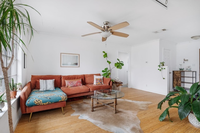 living room with hardwood / wood-style flooring, ceiling fan, and ornamental molding