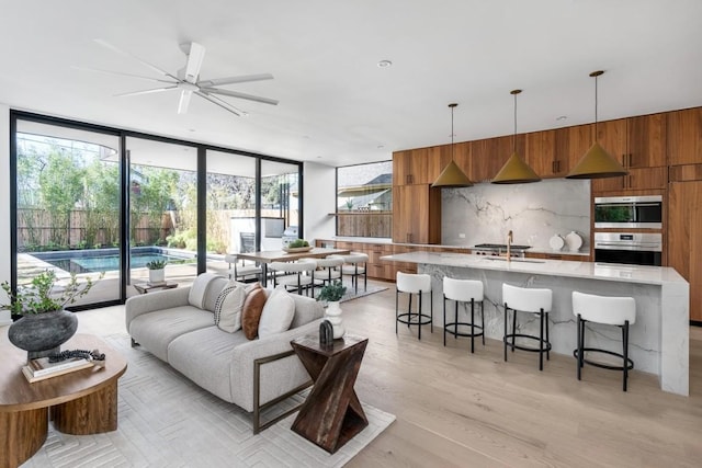 living room with sink, light hardwood / wood-style floors, and expansive windows