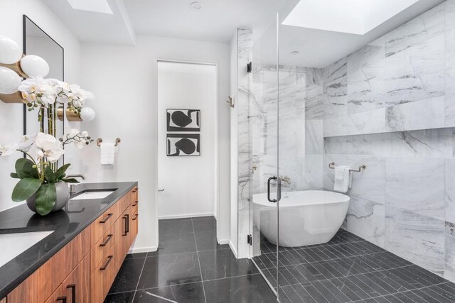 bathroom featuring vanity, shower with separate bathtub, tile walls, and a skylight