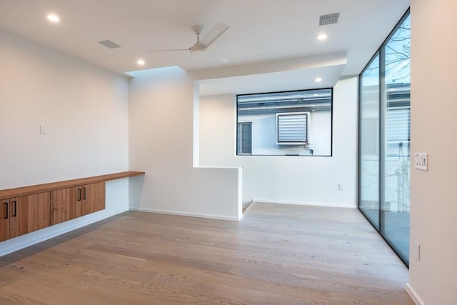 spare room with ceiling fan, floor to ceiling windows, and light hardwood / wood-style floors