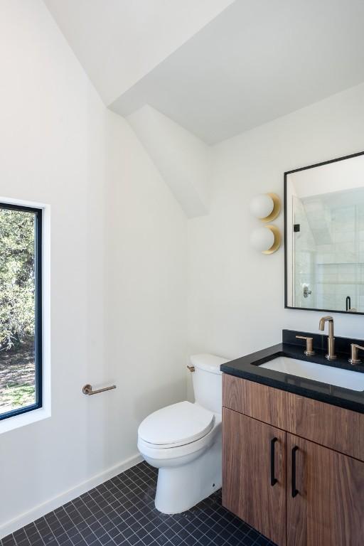 bathroom with lofted ceiling, toilet, a shower with shower door, vanity, and tile patterned flooring