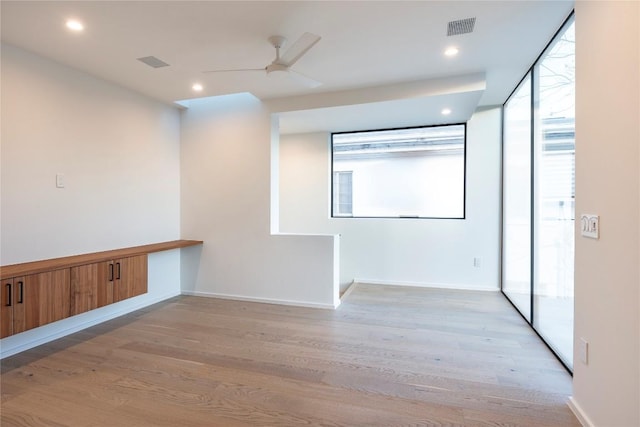 spare room with ceiling fan and light wood-type flooring