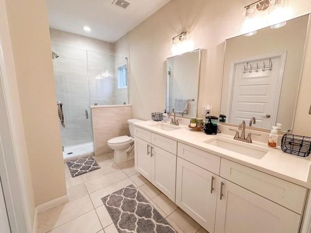 bathroom with vanity, a shower with shower door, tile patterned floors, and toilet