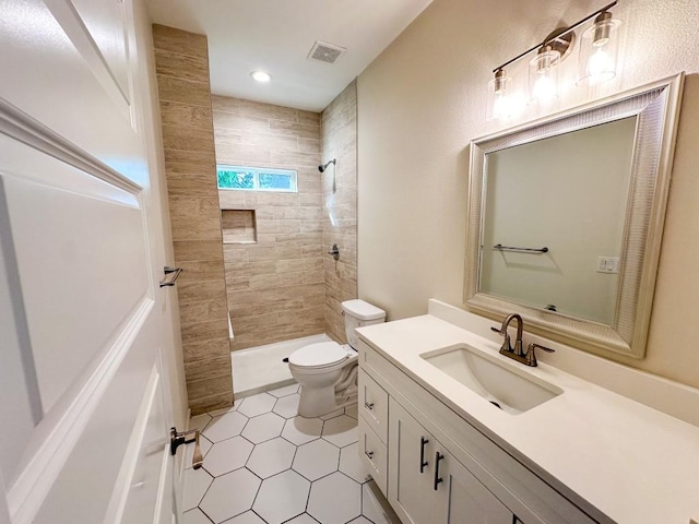 803 4th St, Lockhart, TX 78644 - full bath featuring toilet, vanity, tiled shower, tile patterned flooring, and recessed lighting