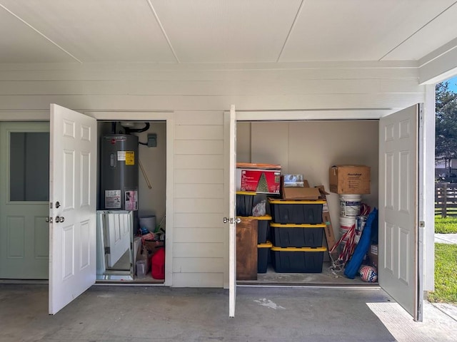 garage with water heater and electric water heater