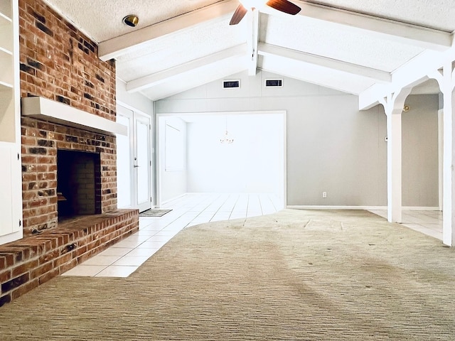 unfurnished living room featuring light tile patterned flooring, lofted ceiling with beams, ceiling fan, a brick fireplace, and a textured ceiling