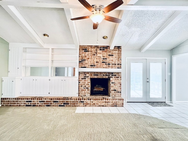 unfurnished living room with french doors, light tile patterned flooring, a textured ceiling, ceiling fan, and a fireplace