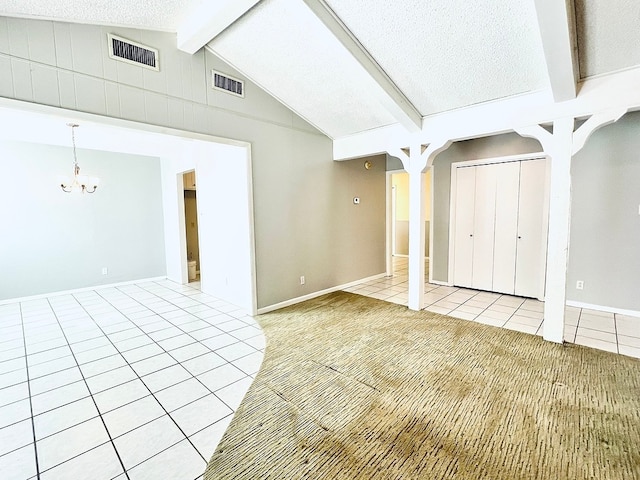 basement featuring a chandelier, a textured ceiling, and light tile patterned floors