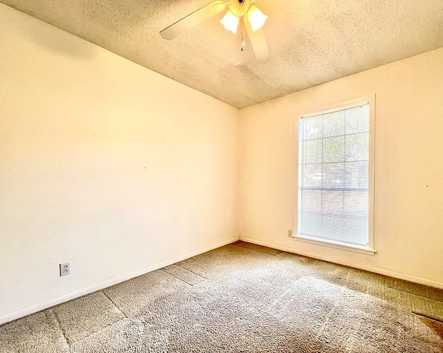 empty room featuring ceiling fan, a textured ceiling, and carpet flooring