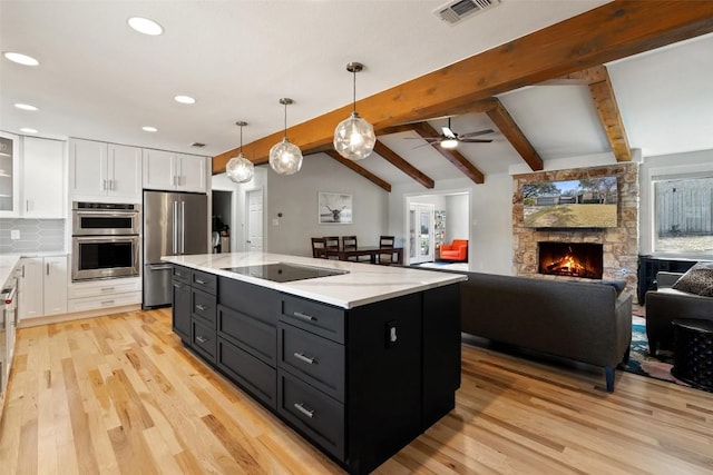 kitchen featuring hanging light fixtures, stainless steel appliances, light hardwood / wood-style floors, white cabinets, and a kitchen island