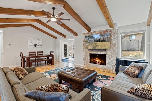 living room featuring vaulted ceiling with beams, hardwood / wood-style flooring, a fireplace, and ceiling fan