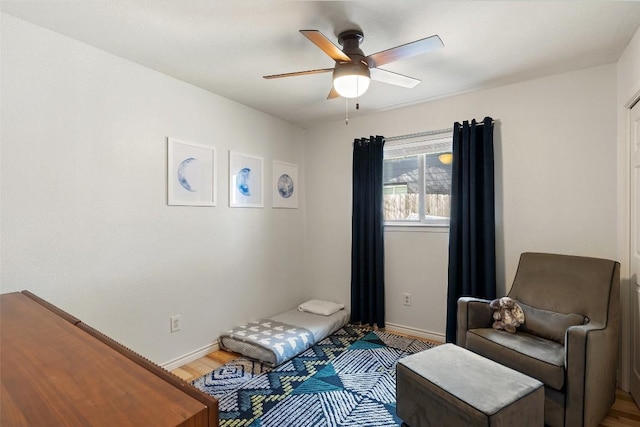 sitting room with hardwood / wood-style flooring and ceiling fan