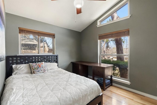 bedroom with multiple windows, vaulted ceiling, hardwood / wood-style floors, and ceiling fan