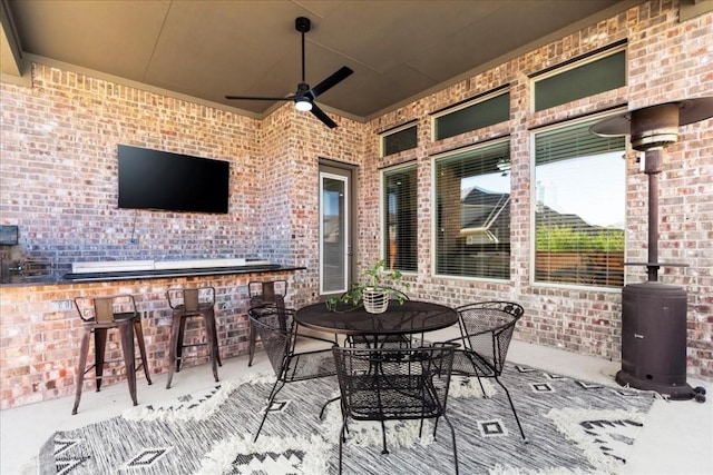 view of patio featuring exterior bar and ceiling fan