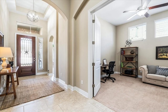 entrance foyer with light carpet, a towering ceiling, and a chandelier