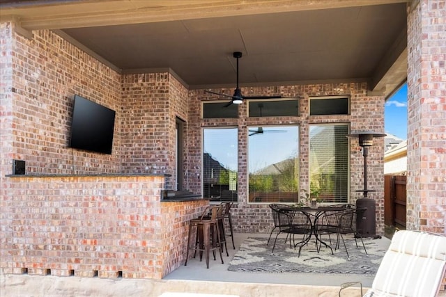 view of patio with a bar and ceiling fan