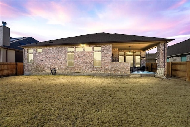 back house at dusk with a yard