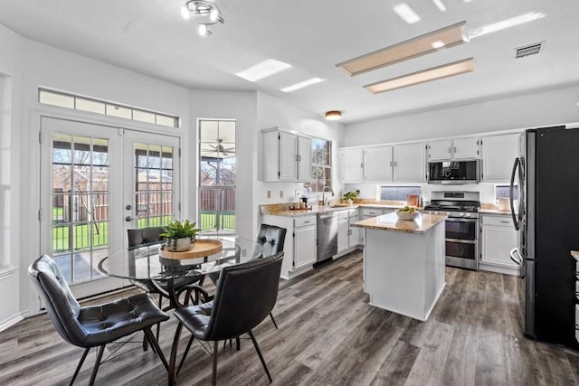 kitchen featuring appliances with stainless steel finishes, dark hardwood / wood-style floors, white cabinetry, a center island, and french doors