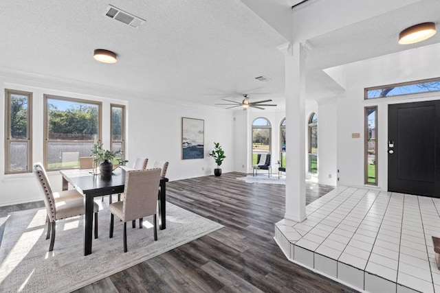 dining area with ceiling fan, dark hardwood / wood-style flooring, and a textured ceiling