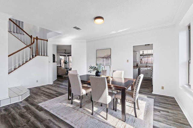 dining space with dark hardwood / wood-style flooring, crown molding, and a textured ceiling