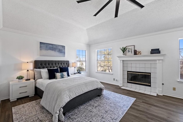 bedroom featuring crown molding, dark wood-type flooring, a fireplace, and a textured ceiling