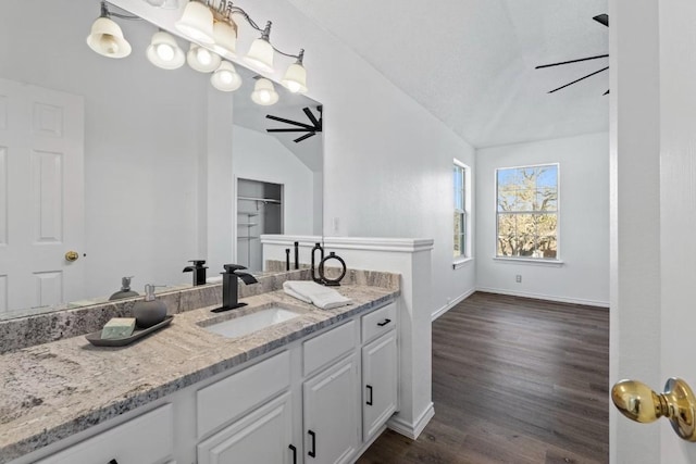 bathroom featuring ceiling fan, wood-type flooring, vaulted ceiling, and vanity