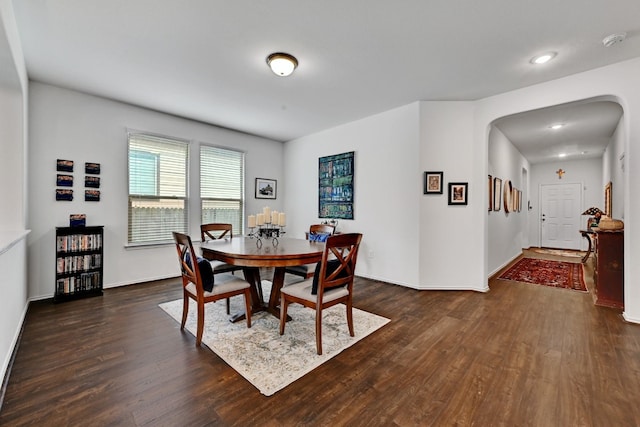 7617 Ballydawn Dr, Austin, TX 78744 - dining room with arched walkways, dark wood finished floors, baseboards, and recessed lighting