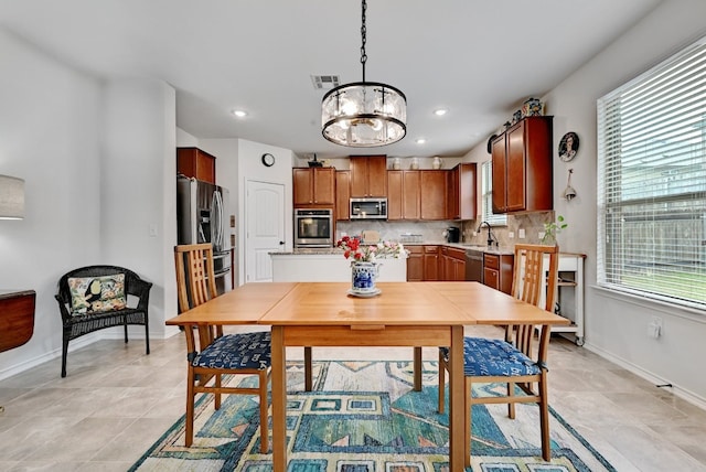 dining space with sink and a chandelier