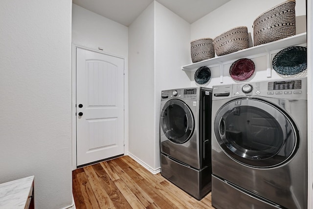 7617 Ballydawn Dr, Austin, TX 78744 - laundry area featuring light wood finished floors, washer and clothes dryer, and baseboards