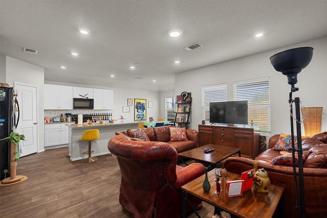 living room with dark wood-type flooring and a textured ceiling