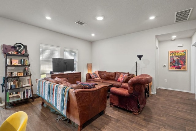 living room featuring dark wood-type flooring and a textured ceiling