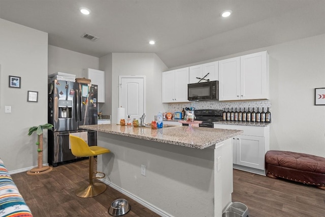 kitchen with white cabinets, a kitchen bar, light stone counters, black appliances, and a center island with sink